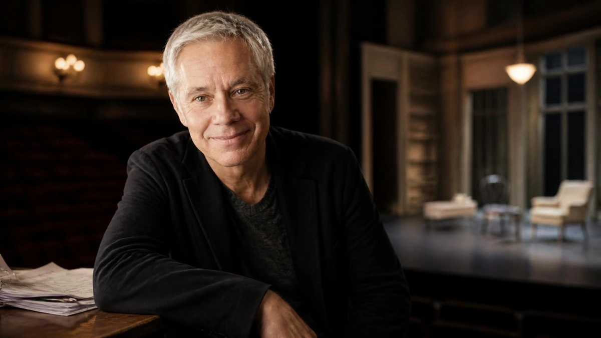 Portrait souriant de l'acteur et metteur en scène José Paul sur la scène d'un théâtre