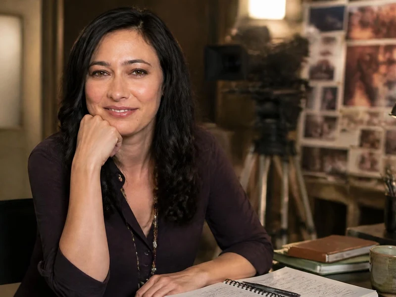 Portrait de Katrina Holden Bronson assise à son bureau avec du matériel de tournage en arrière-plan