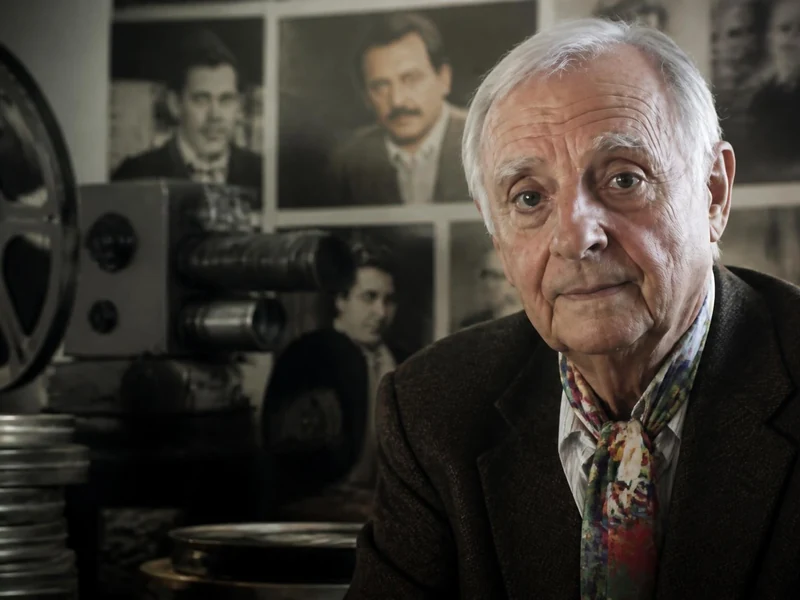 Portrait de Marc Lamole posant devant des bobines de films et une ancienne caméra de cinéma