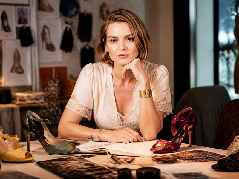 Patricia Blanchet travaillant sur ses créations de chaussures dans son atelier rempli de modèles et de croquis