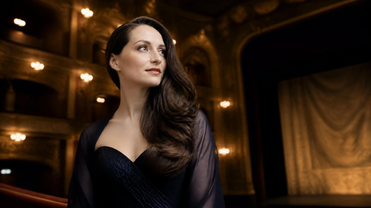 Portrait élégant de la soprano Camille Schnoor posant dans une salle d'opéra aux lumières tamisées