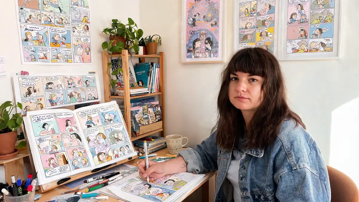 Salomé Lahoche travaille sur ses planches de bande dessinée à son bureau entourée de ses créations