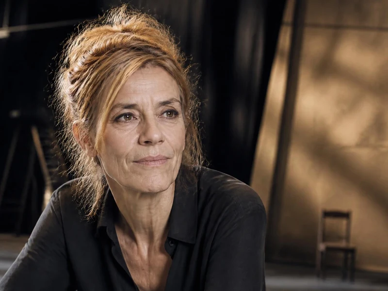 Portrait de la comédienne Sylvie Orcier avec les cheveux relevés dans un décor de théâtre épuré